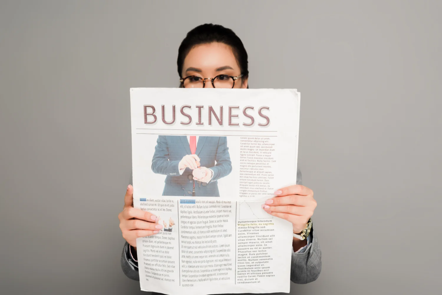 A woman holding up a business newspaper